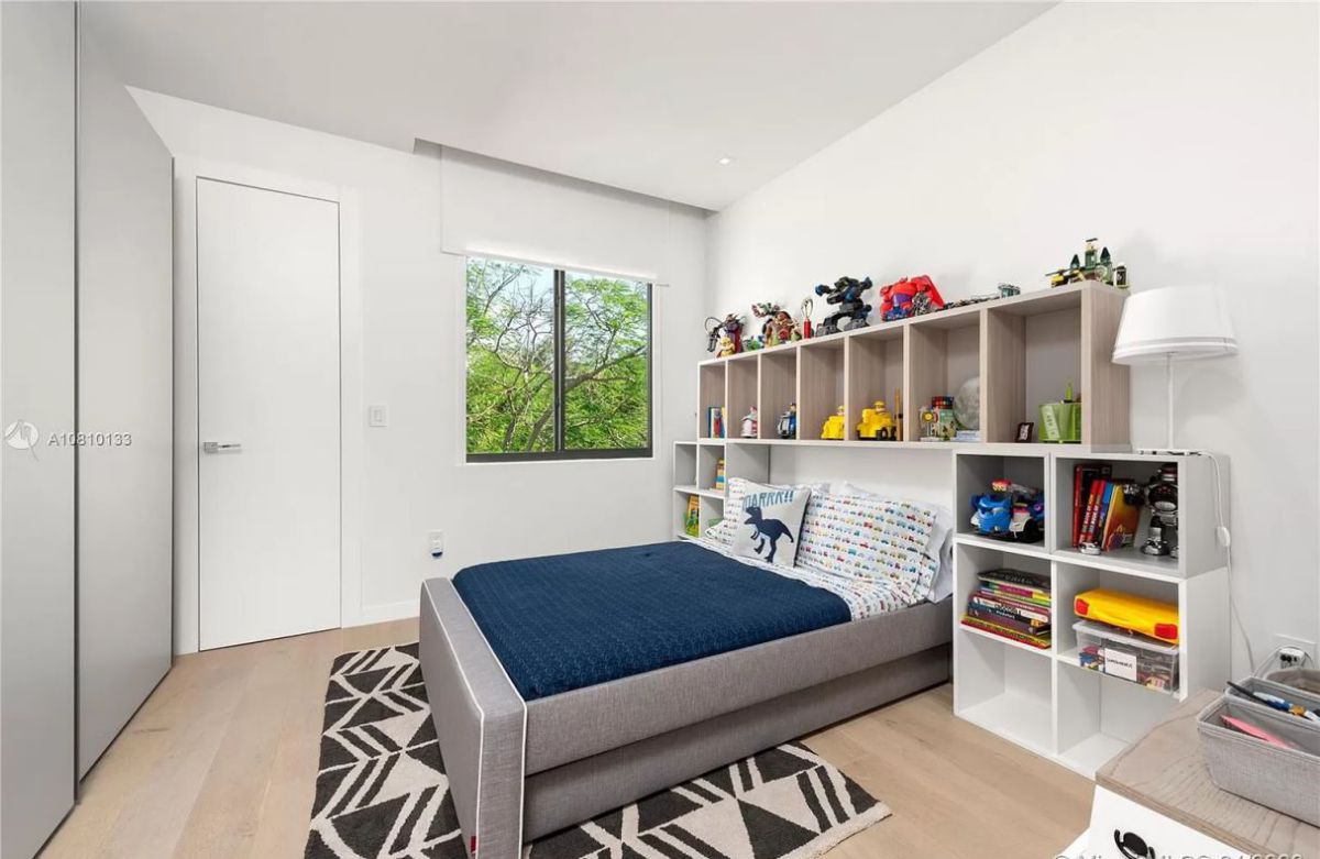 This floor carpet pattern brings a pop of color to the otherwise monochromatic space. It serves as the visual center of the space while serving as an accent piece. A carpet can provide some cozy warmth to a room with a basic white color scheme because plain white rooms frequently seem a little chilly. The bedroom carpet is decorated with a geometric pattern. The carpet's off-white and black hues add a splash of color and tie the rest of the interiors together, making it a crucial component of the interior design.