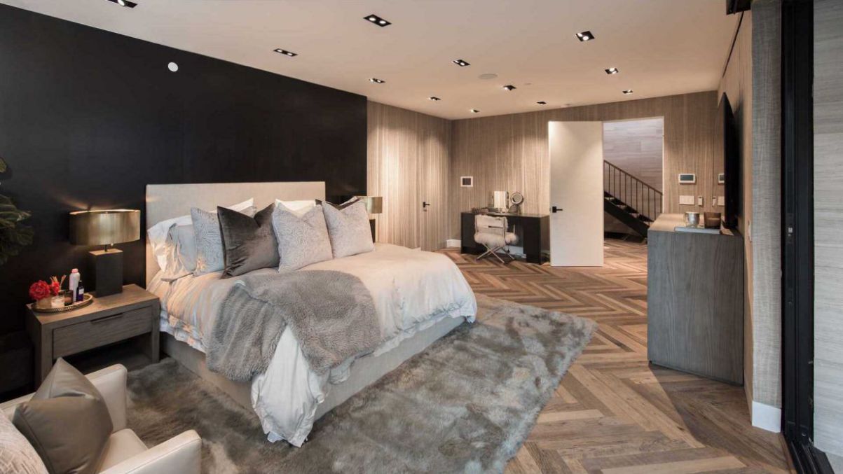 One of our favorite examples is this lovely bedroom, which was created by layering various patterns and textures in combinations of brown and cream tones. The headboard and contrasting black walls offer depth and visual intrigue, while the reclaimed wood wall highlights the room.