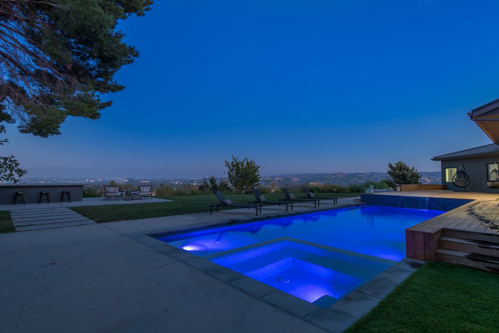 The Hidden Hills House is an absolutely extraordinary single story modern with explosive panoramic unobstructed city light views now available for sale. This home located at 5550 Bonneville Rd, Hidden Hills, California; offering 4 bedrooms and 5 bathrooms with over 4,800 square feet of living spaces.