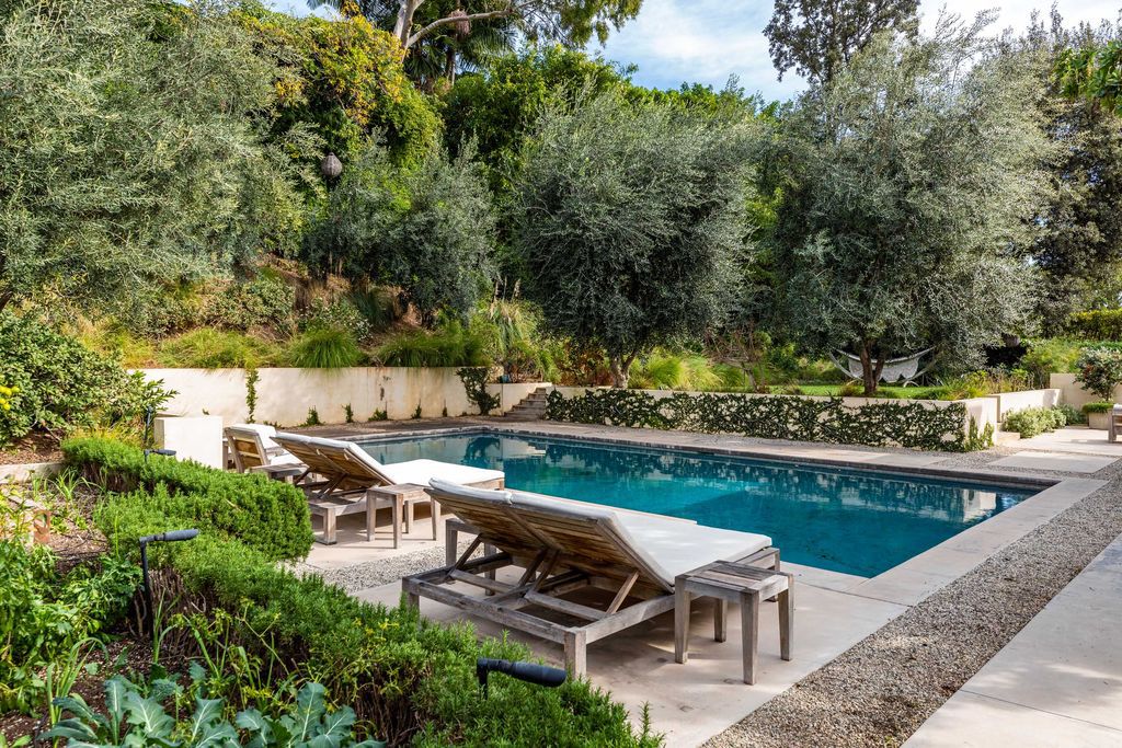 The Mid Century Home in Beverly Hills is a organic property offers total privacy, effortless indoor - outdoor living and unparalleled treetop views now available for sale. This home located at 1030 Woodland Dr, Beverly Hills, California; offering 4 bedrooms and 4 bathrooms with over 4,400 square feet of living spaces.
