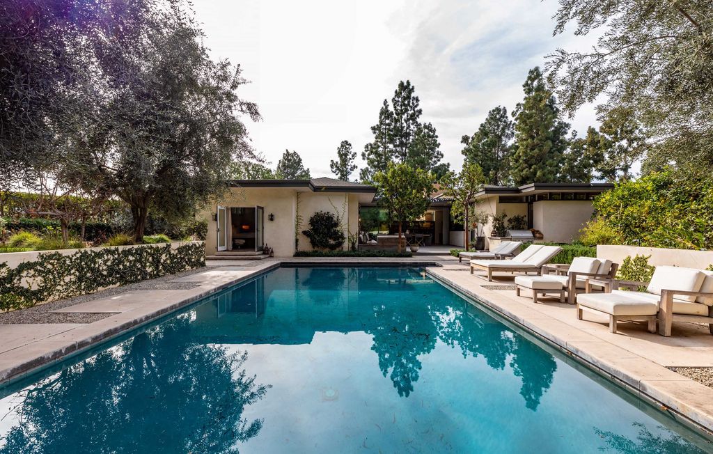 The Mid Century Home in Beverly Hills is a organic property offers total privacy, effortless indoor - outdoor living and unparalleled treetop views now available for sale. This home located at 1030 Woodland Dr, Beverly Hills, California; offering 4 bedrooms and 4 bathrooms with over 4,400 square feet of living spaces.