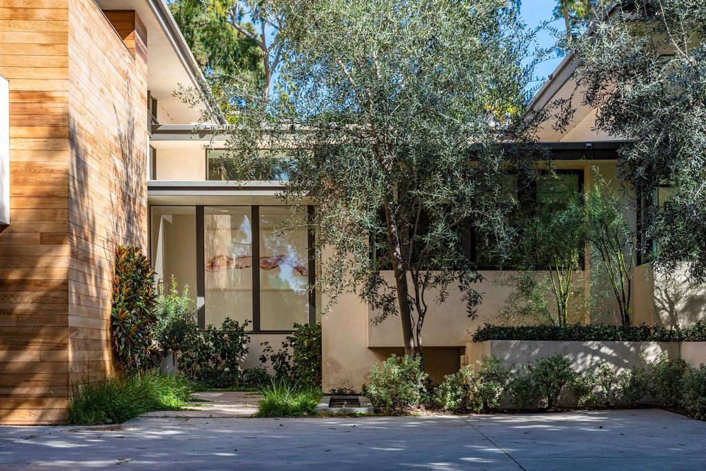 The Mid Century Home in Beverly Hills is a organic property offers total privacy, effortless indoor - outdoor living and unparalleled treetop views now available for sale. This home located at 1030 Woodland Dr, Beverly Hills, California; offering 4 bedrooms and 4 bathrooms with over 4,400 square feet of living spaces.
