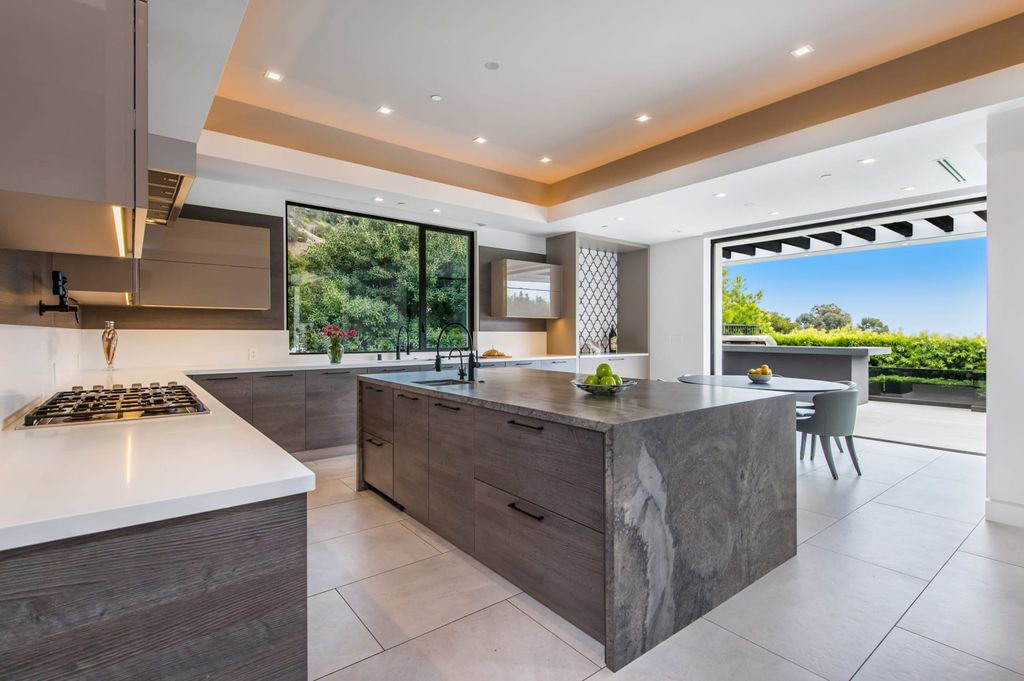 The Contemporary Home in Beverly Hills with panoramic views is built with soaring ceilings, clean lines, and sleek intricacies now available for sale. This home located at 1041 N Hillcrest Rd, Beverly Hills, California