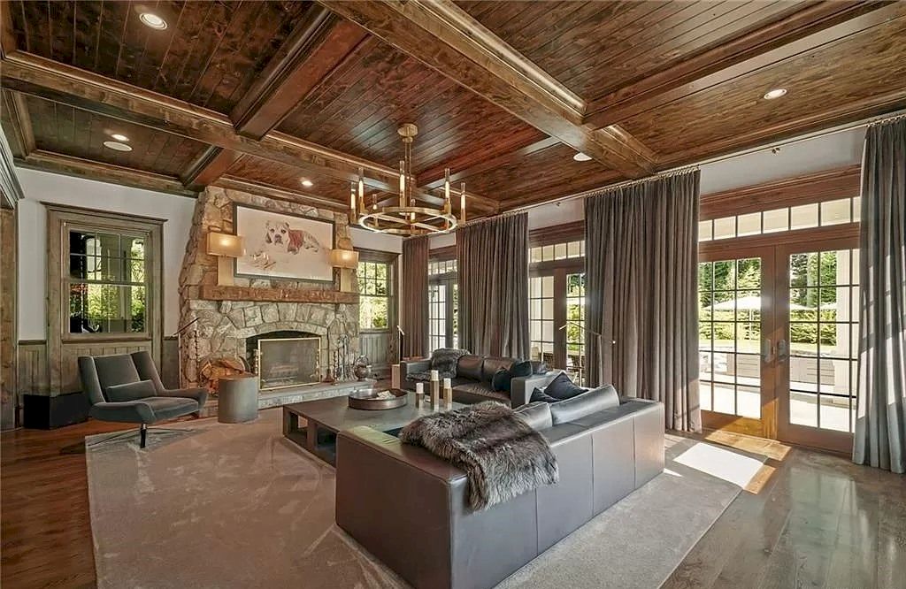With its magnificent layout, perfect symmetry both vertically and horizontally, and a chandelier that offers just the proper amount of light to the space, this living room is truly in motion. Meanwhile, the rustic and simple dark brown leather sofa style unifies and connects the space. The installed curtains with the same hue are adding more depth to this rustic modern room.