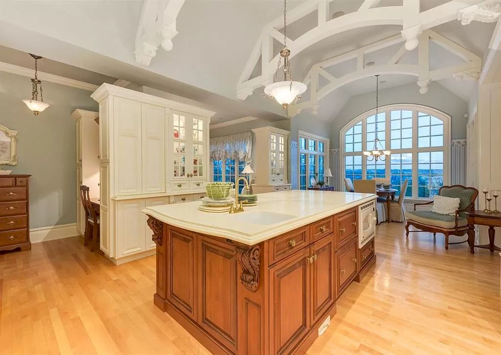 The Magnificent Home in Alberta features extensive hand-hewn grey Canmore limestone, soaring peaks, arched windows, and a majestic sloped roof now available for sale