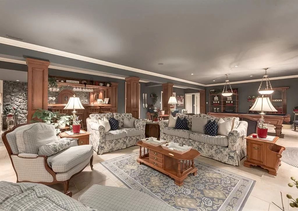 The Magnificent Home in Alberta features extensive hand-hewn grey Canmore limestone, soaring peaks, arched windows, and a majestic sloped roof now available for sale