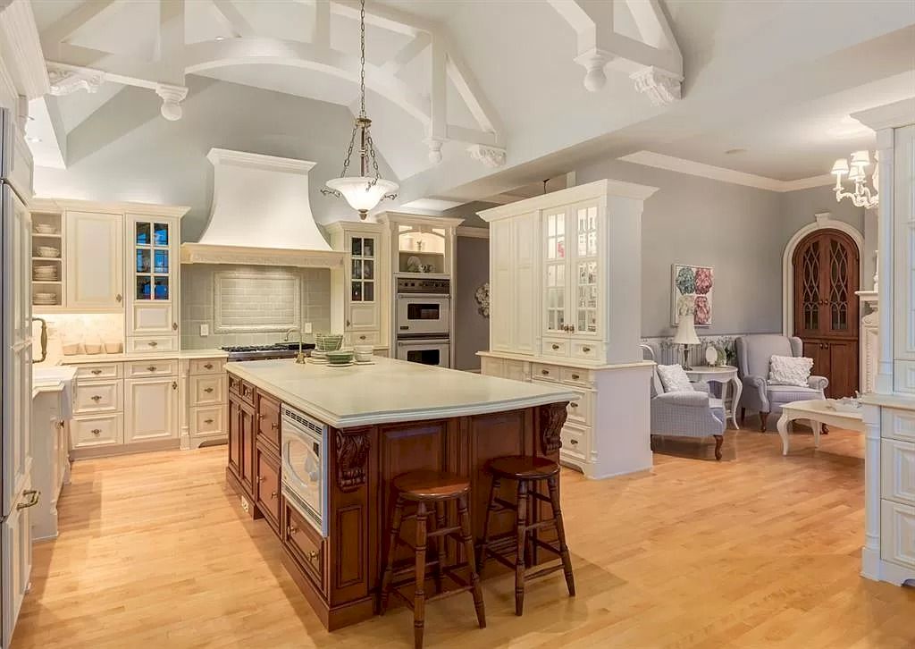The Magnificent Home in Alberta features extensive hand-hewn grey Canmore limestone, soaring peaks, arched windows, and a majestic sloped roof now available for sale