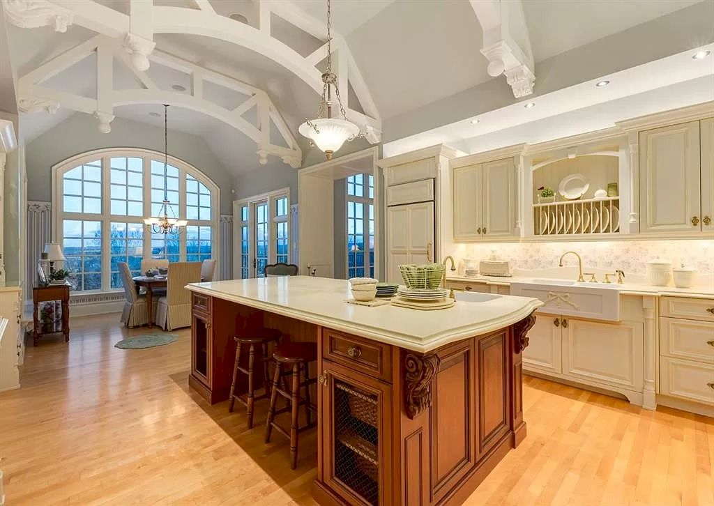 The Magnificent Home in Alberta features extensive hand-hewn grey Canmore limestone, soaring peaks, arched windows, and a majestic sloped roof now available for sale