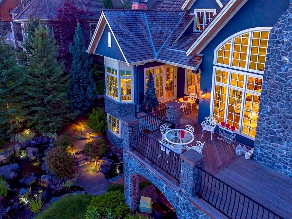 The Magnificent Home in Alberta features extensive hand-hewn grey Canmore limestone, soaring peaks, arched windows, and a majestic sloped roof now available for sale