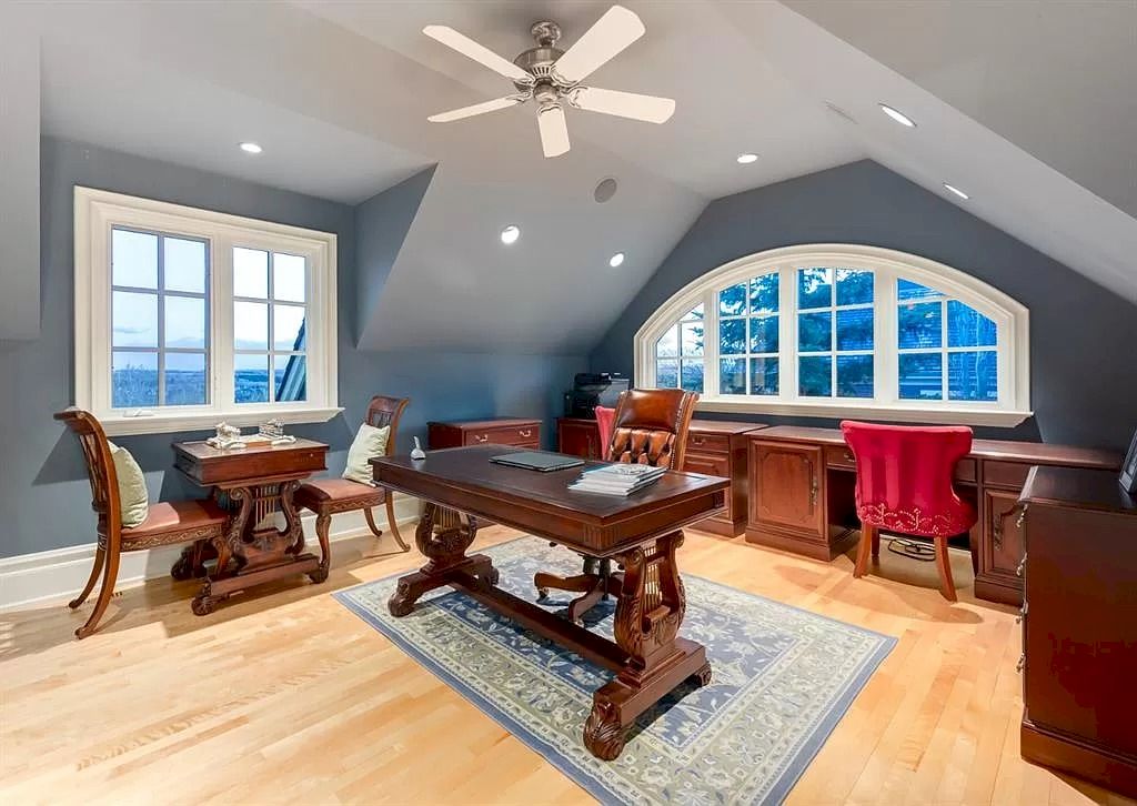 The Magnificent Home in Alberta features extensive hand-hewn grey Canmore limestone, soaring peaks, arched windows, and a majestic sloped roof now available for sale