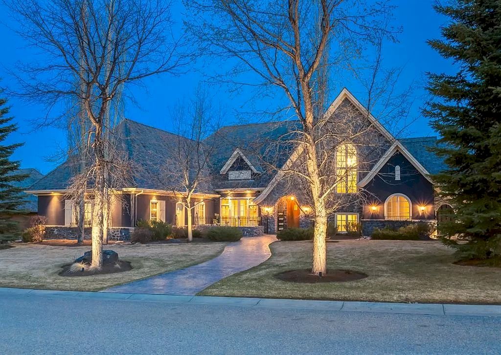 The Magnificent Home in Alberta features extensive hand-hewn grey Canmore limestone, soaring peaks, arched windows, and a majestic sloped roof now available for sale