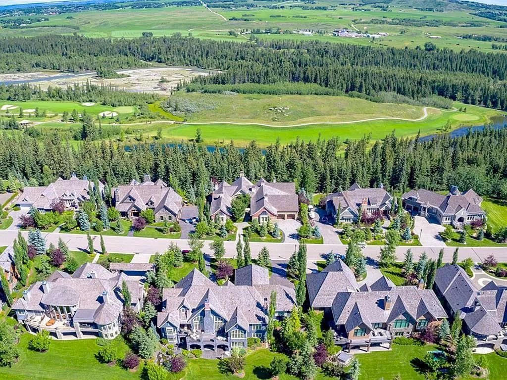 The Magnificent Home in Alberta features extensive hand-hewn grey Canmore limestone, soaring peaks, arched windows, and a majestic sloped roof now available for sale