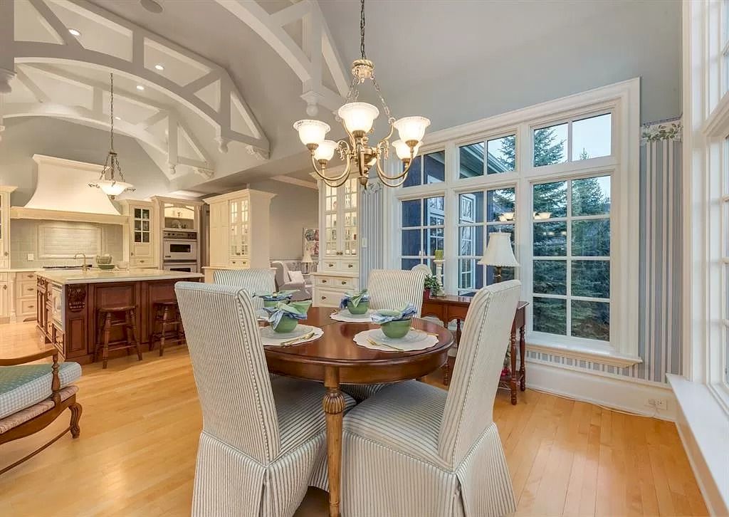 The Magnificent Home in Alberta features extensive hand-hewn grey Canmore limestone, soaring peaks, arched windows, and a majestic sloped roof now available for sale