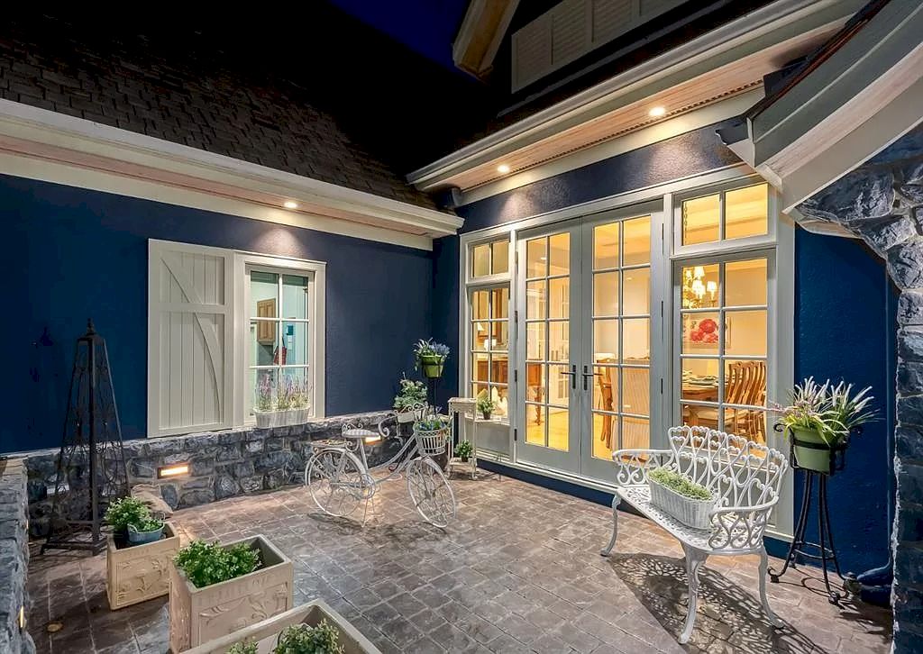 The Magnificent Home in Alberta features extensive hand-hewn grey Canmore limestone, soaring peaks, arched windows, and a majestic sloped roof now available for sale