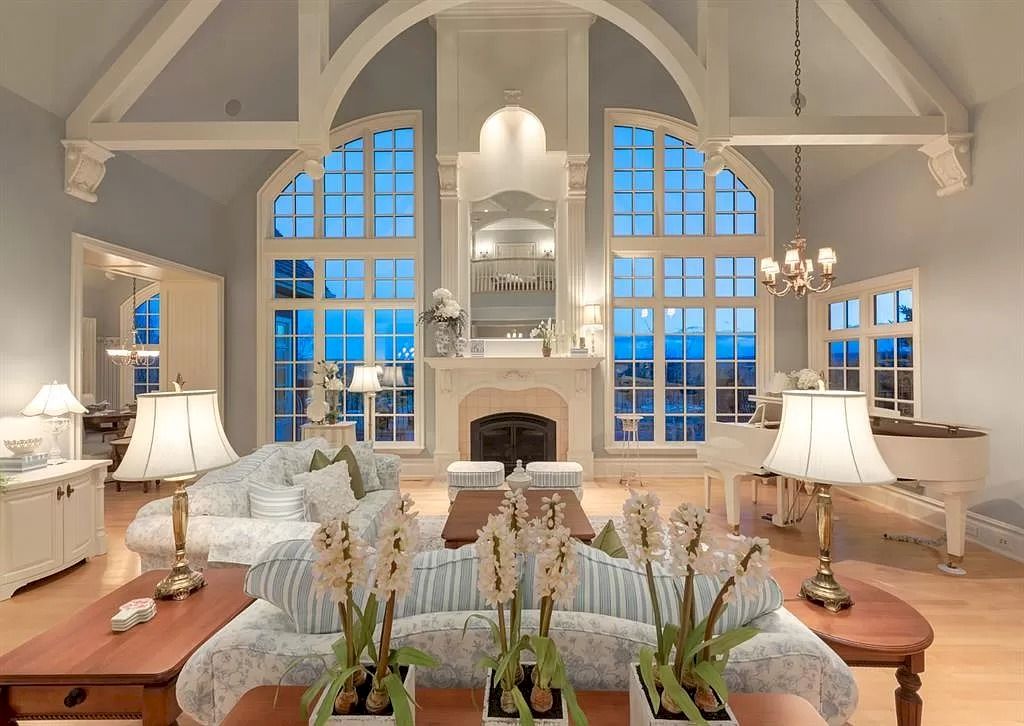 The Magnificent Home in Alberta features extensive hand-hewn grey Canmore limestone, soaring peaks, arched windows, and a majestic sloped roof now available for sale
