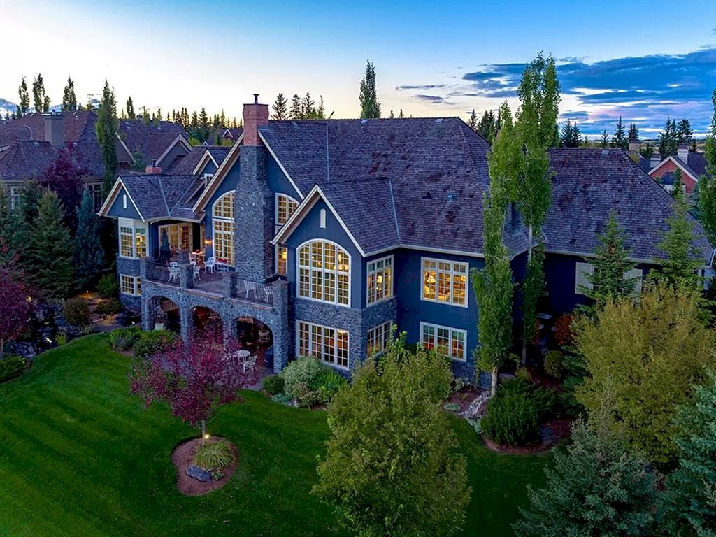 The Magnificent Home in Alberta features extensive hand-hewn grey Canmore limestone, soaring peaks, arched windows, and a majestic sloped roof now available for sale