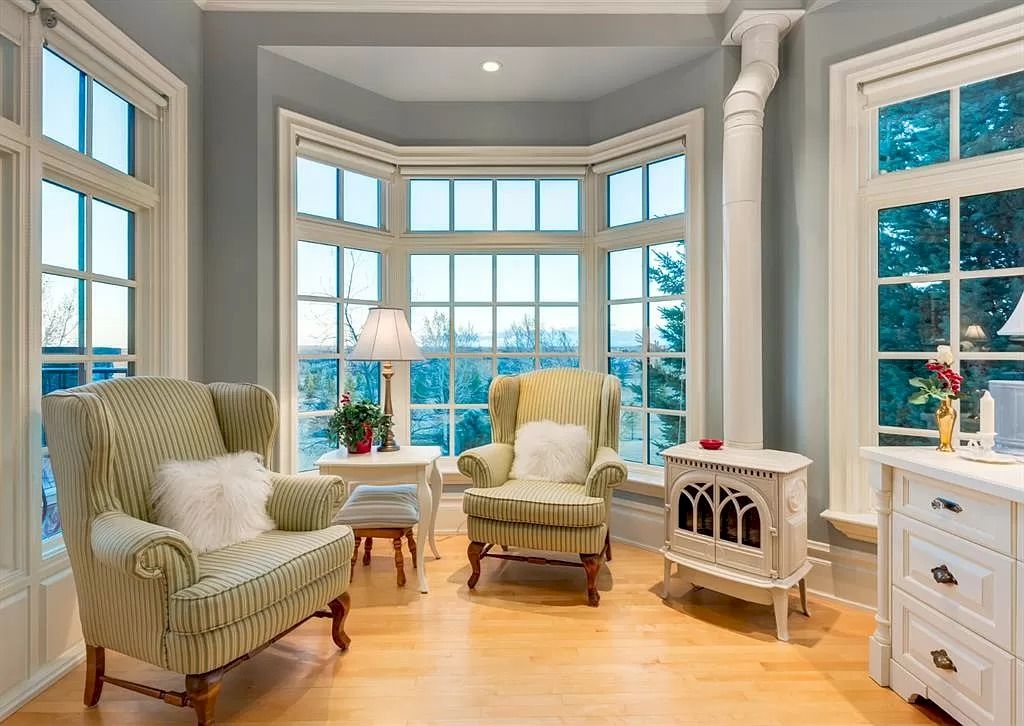 The Magnificent Home in Alberta features extensive hand-hewn grey Canmore limestone, soaring peaks, arched windows, and a majestic sloped roof now available for sale