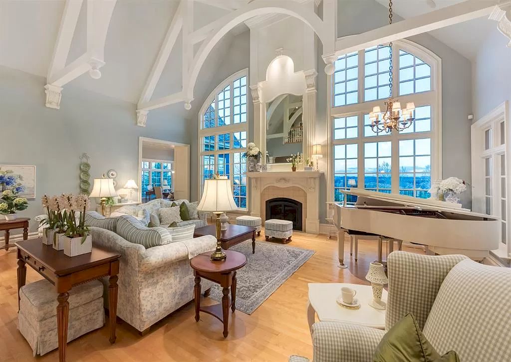 The Magnificent Home in Alberta features extensive hand-hewn grey Canmore limestone, soaring peaks, arched windows, and a majestic sloped roof now available for sale