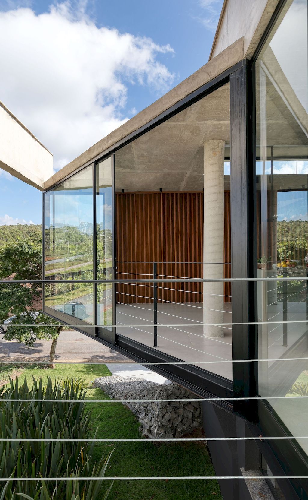 House 7 Patios, supported on slope with vegetation by TETRO Arquitetura