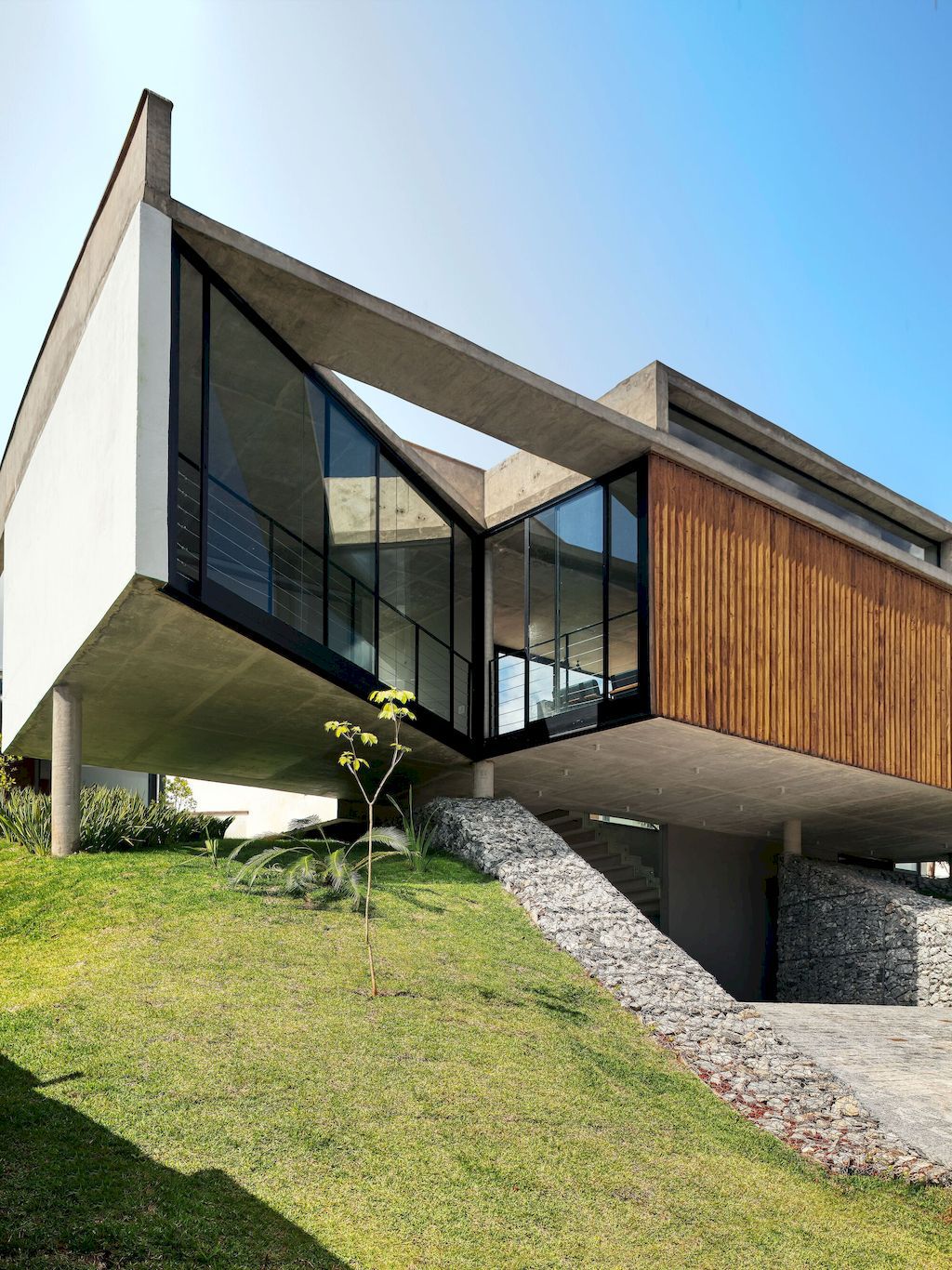 House 7 Patios supported on slope with vegetation by TETRO Arquitetura 7