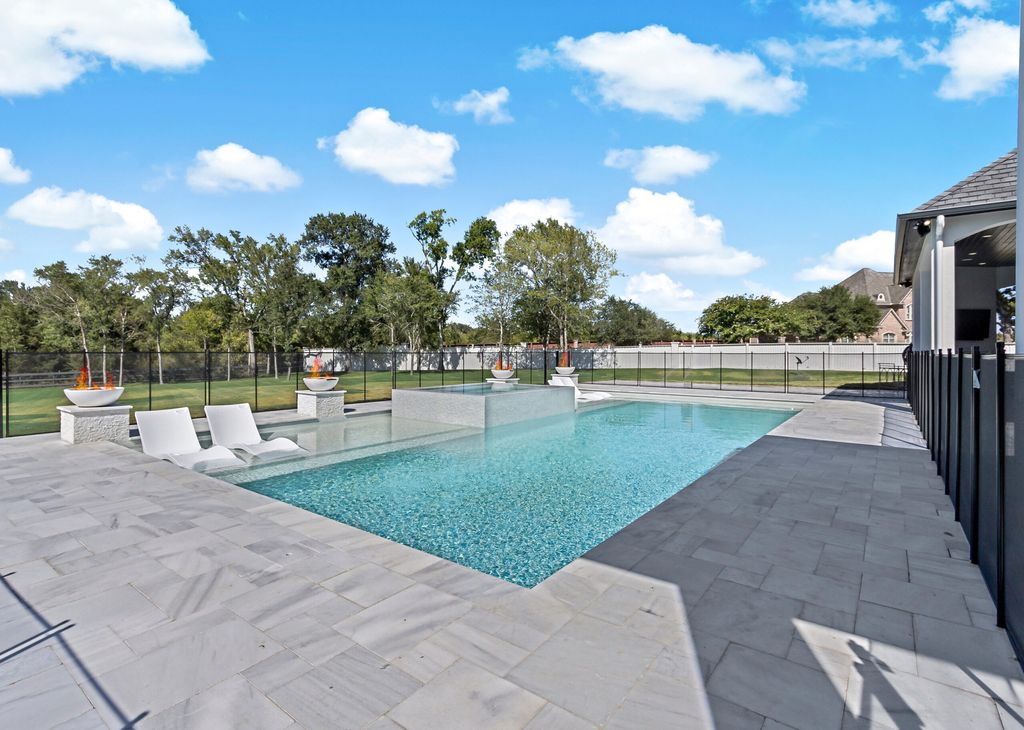 The Home in Bryan, a luxurious custom residence has a open concept great room complete with 20-foot ceilings, a beautifully designed pool and elegant outdoor entertaining area. This home located at 7163 Riverstone Dr, Bryan, Texas.