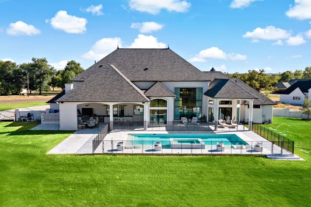 The Home in Bryan, a luxurious custom residence has a open concept great room complete with 20-foot ceilings, a beautifully designed pool and elegant outdoor entertaining area. This home located at 7163 Riverstone Dr, Bryan, Texas.