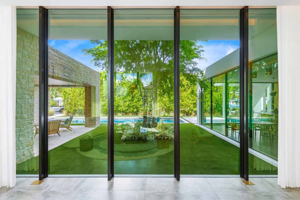 121 Nurmi Dr, Fort Lauderdale, Florida is a sophisticated modernist estate built in 2020 by renown architect Daniel Kahan from Smith and Moore with unbelievable features including beautiful lighting, private gardens, summer kitchen and more.