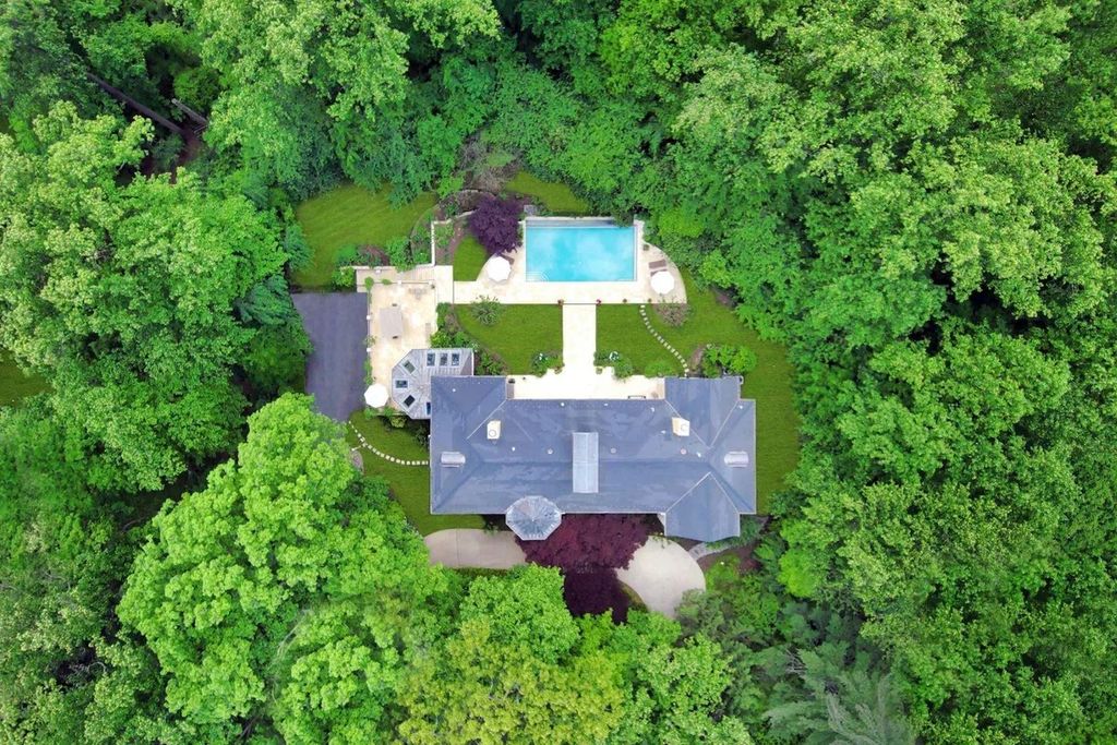 The Home in Bethesda features a private balcony seemingly floating in the woods, while an oversized walk-in closet and spa-inspired bath with separate vanities, now available for sale. This home located at 8814 Chalon Dr, Bethesda, Maryland