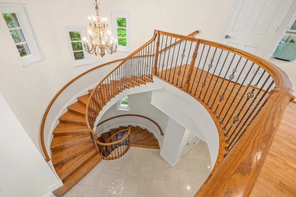 The Home in Bethesda features a private balcony seemingly floating in the woods, while an oversized walk-in closet and spa-inspired bath with separate vanities, now available for sale. This home located at 8814 Chalon Dr, Bethesda, Maryland