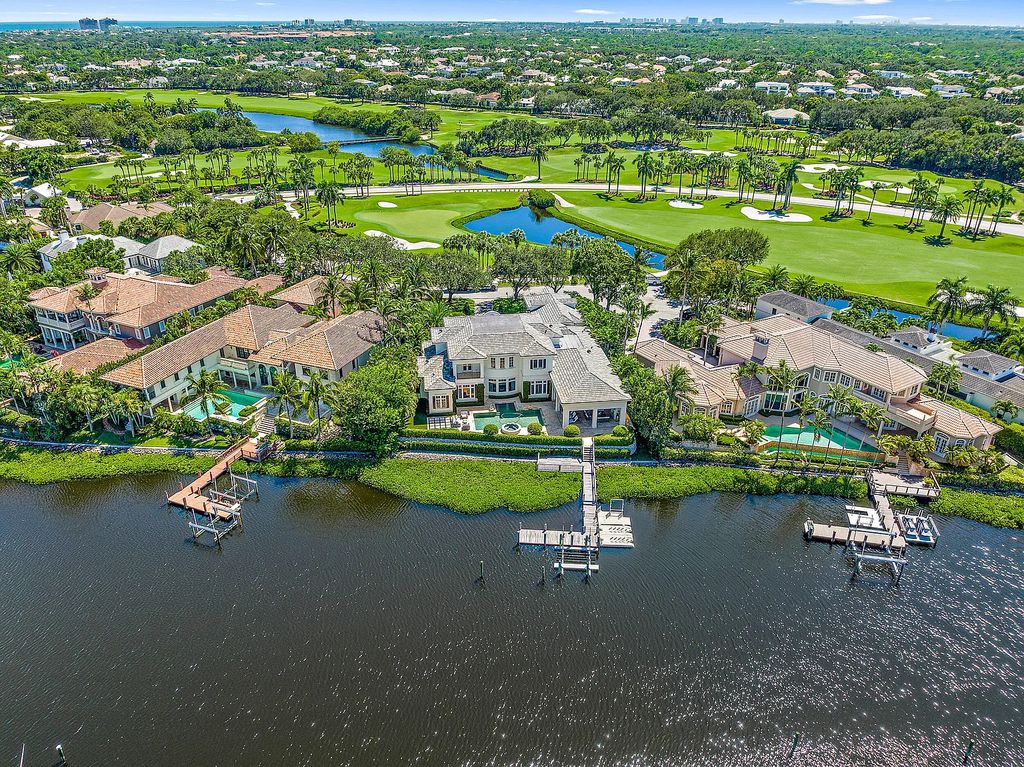 The Estate in Jupiter, a luxurious home on a quiet cul-de-sac street close to The Club features perfect outdoor living space including covered and screen outdoor living room with summer kitchen, fireplace, amazing water view pool is now available for sale. This home located at 109 Schooner Ln, Jupiter, Florida