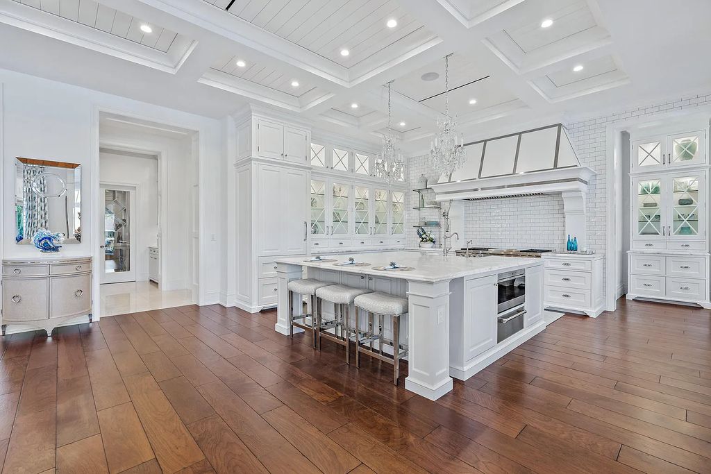 The Estate in Jupiter, a luxurious home on a quiet cul-de-sac street close to The Club features perfect outdoor living space including covered and screen outdoor living room with summer kitchen, fireplace, amazing water view pool is now available for sale. This home located at 109 Schooner Ln, Jupiter, Florida
