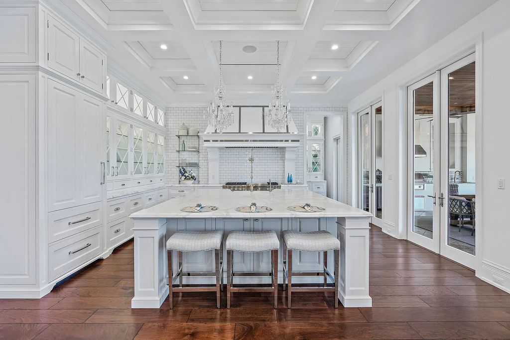 The Estate in Jupiter, a luxurious home on a quiet cul-de-sac street close to The Club features perfect outdoor living space including covered and screen outdoor living room with summer kitchen, fireplace, amazing water view pool is now available for sale. This home located at 109 Schooner Ln, Jupiter, Florida