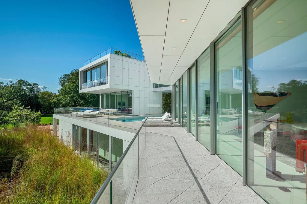 34 Cobb Isle Road, Water Mill, New York is a contemporary architectural masterpiece by renowned architect Roger Ferris overlooking Mecox Bay and the Atlantic Ocean, with 2 docks, plus a fully restored guest house on its own single and separate lot.