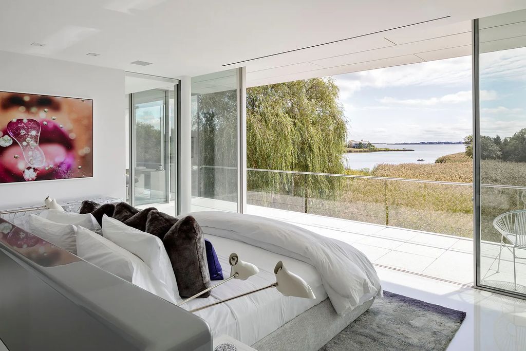 34 Cobb Isle Road, Water Mill, New York is a contemporary architectural masterpiece by renowned architect Roger Ferris overlooking Mecox Bay and the Atlantic Ocean, with 2 docks, plus a fully restored guest house on its own single and separate lot.