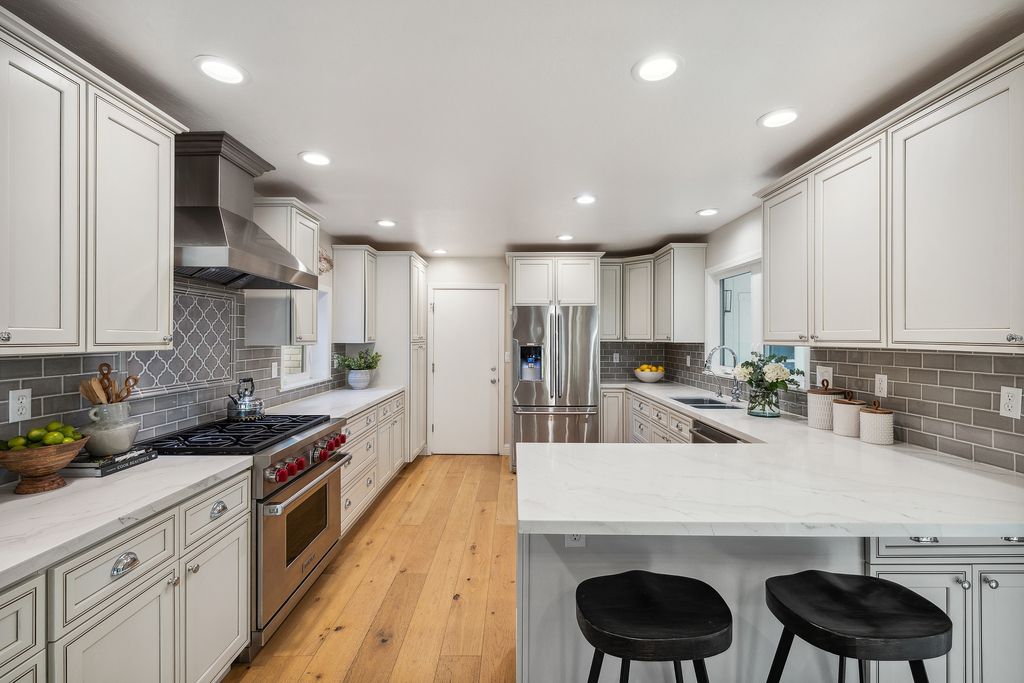 1941 Parkmont Drive, Alamo, California is beautiful remodeled custom home features a resort-like backyard with pool, spa, outdoor kitchen, built-in fire pit, bocce court, expansive level grassy area to play, sport court location, producing vineyard, vegetable garden beds, & fruit trees.