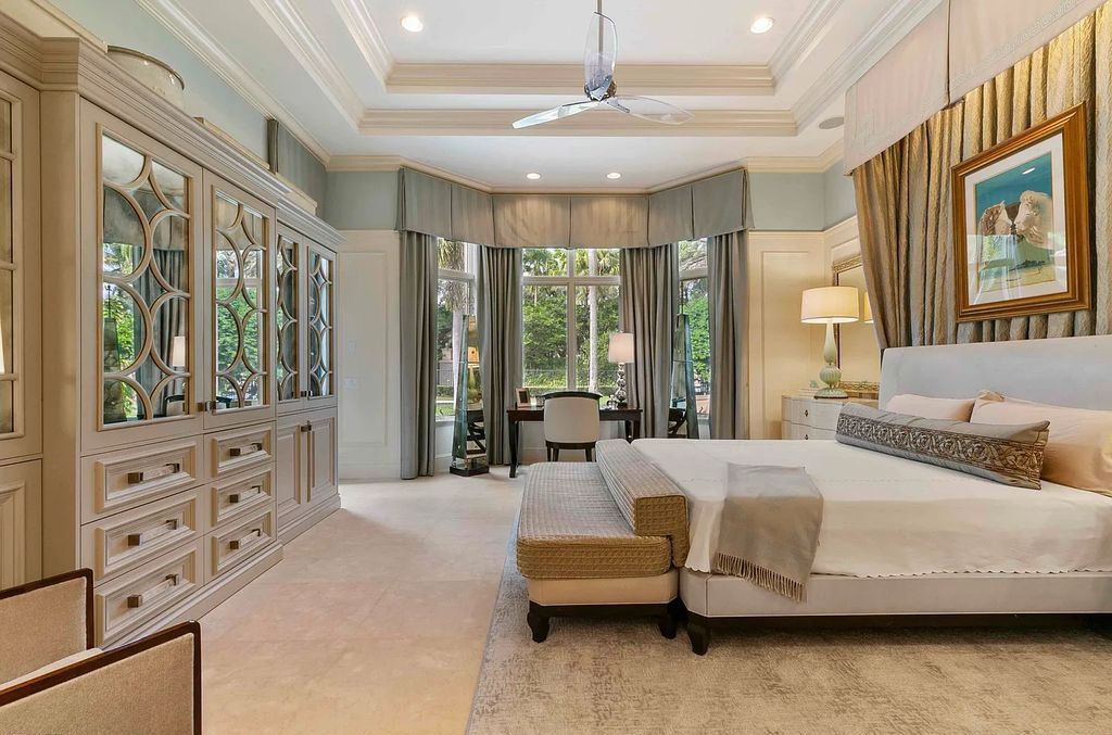 11701 San Sovino Court, Palm Beach Gardens, Florida is a private enclave on one of the most coveted streets within Old Palm Golf Club with tropical water feature view, expansive covered lanai, breezy awnings, heated pool & spa and more.