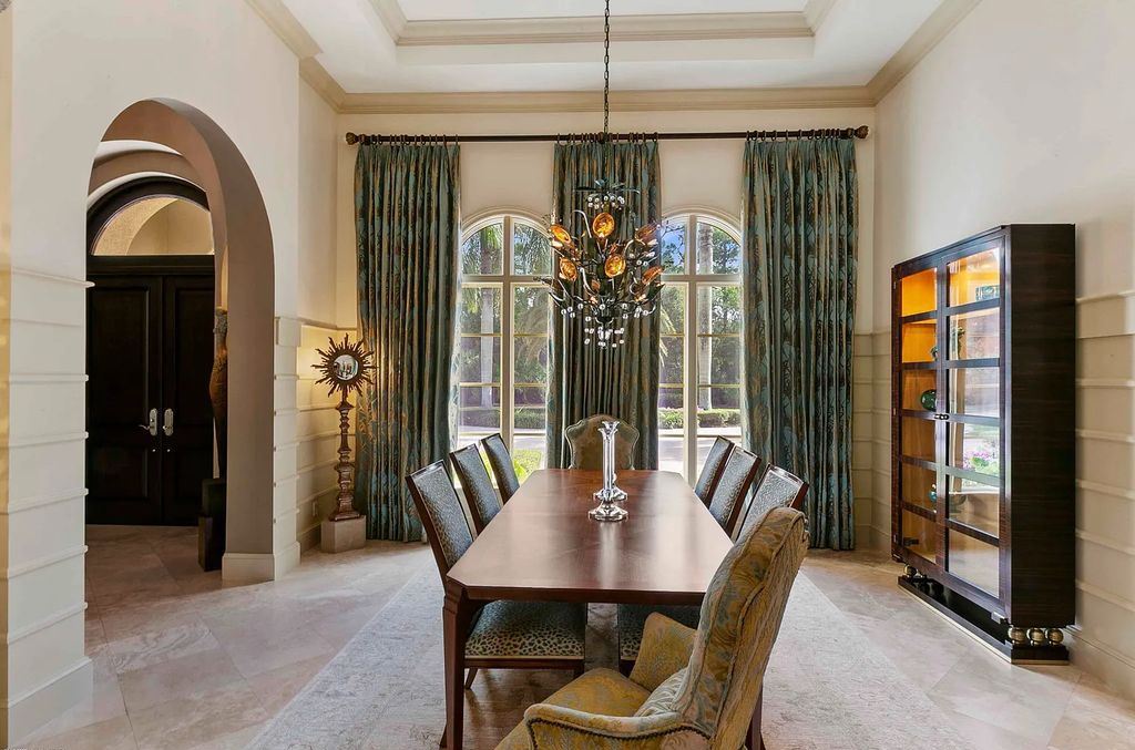 11701 San Sovino Court, Palm Beach Gardens, Florida is a private enclave on one of the most coveted streets within Old Palm Golf Club with tropical water feature view, expansive covered lanai, breezy awnings, heated pool & spa and more.