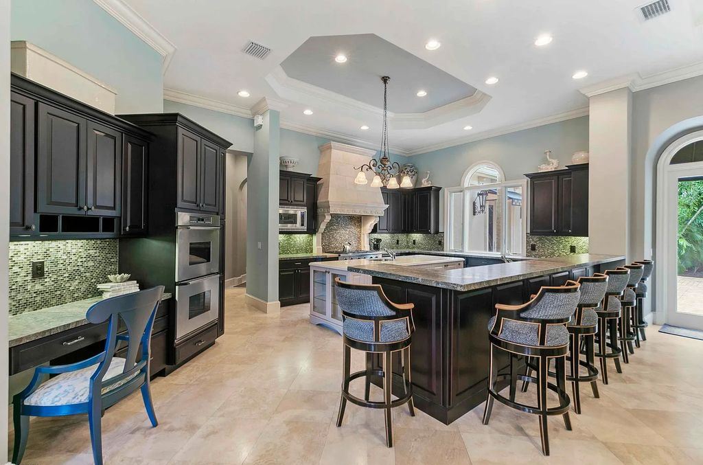 11701 San Sovino Court, Palm Beach Gardens, Florida is a private enclave on one of the most coveted streets within Old Palm Golf Club with tropical water feature view, expansive covered lanai, breezy awnings, heated pool & spa and more.