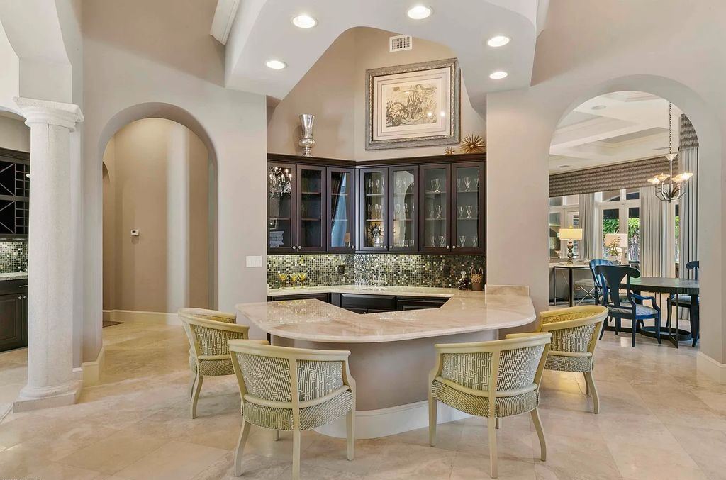 11701 San Sovino Court, Palm Beach Gardens, Florida is a private enclave on one of the most coveted streets within Old Palm Golf Club with tropical water feature view, expansive covered lanai, breezy awnings, heated pool & spa and more.
