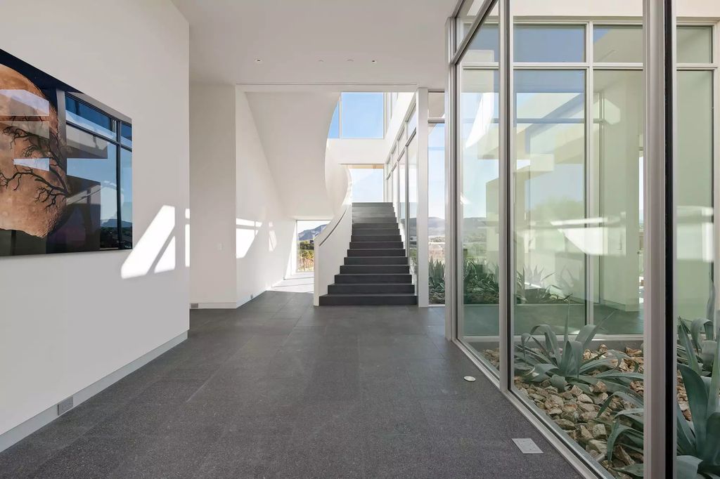 10861 Stardust Drive, Las Vegas, Nevada is spectacular property located in Discovery Land Company’s coveted and exclusive Summit Club offering the ultimate in privacy sitting on its own 1.37-acre peninsula lot.