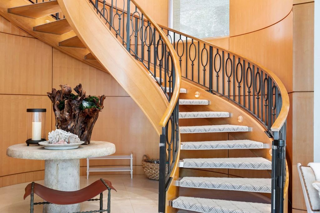 317 Ocean Boulevard, Golden Beach, Florida is an exceptional ocean front estate with luxurious amenities including formal dining room with maple paneling, movie theater, elevator, help quarters, finished basement, gym, and 2 large storage rooms. 