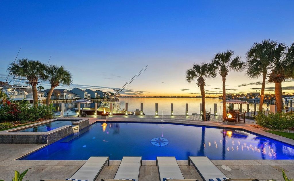 4600 Bay Point Road, Panama City Beach, Florida, is an exceptionally luxurious home with a Tropical Poolside Oasis with smart furnishings, soaring vaulted wood beam ceilings, a curving staircase, and an expansive living room featuring a well-appointed fireplace and triple French doors that lead to the elevated deck. This Home in Panama City Beach offers 6 bedrooms and 8 bathrooms with over 6.000 square feet of living spaces.