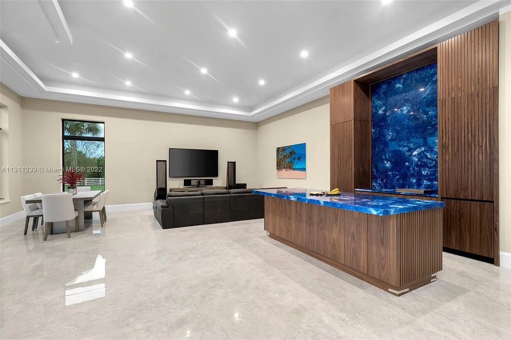 5875 Stone Creek Way, Fort Lauderdale, Florida, built by acclaimed builder Rick Bell, sits on 5 acres and boasts over 20,000 square feet of space. This incredible and one-of-a-kind custom compound's grand estate, including private gates, features volume ceilings, a resort-style pool, and top-of-the-line appliances.