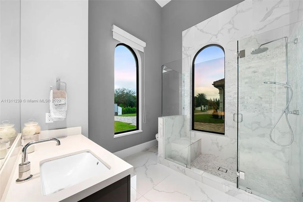 5875 Stone Creek Way, Fort Lauderdale, Florida, built by acclaimed builder Rick Bell, sits on 5 acres and boasts over 20,000 square feet of space. This incredible and one-of-a-kind custom compound's grand estate, including private gates, features volume ceilings, a resort-style pool, and top-of-the-line appliances.