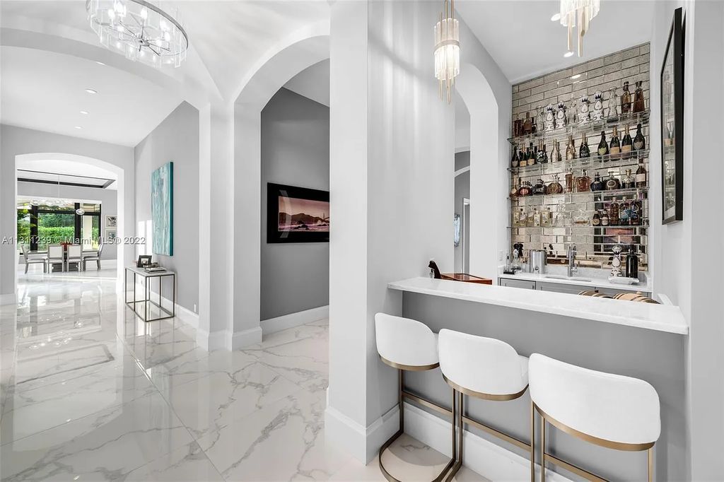 5875 Stone Creek Way, Fort Lauderdale, Florida, built by acclaimed builder Rick Bell, sits on 5 acres and boasts over 20,000 square feet of space. This incredible and one-of-a-kind custom compound's grand estate, including private gates, features volume ceilings, a resort-style pool, and top-of-the-line appliances.