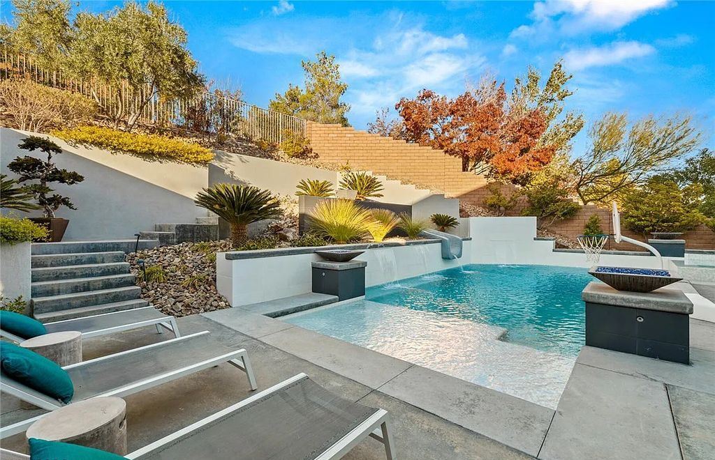 20 Skybird Court, Las Vegas, Nevada is a fully remodeled gem in the enclave of Redhawk behind the guard gates of The Ridges boasting a basketball area, pool with water slide and oversized wet deck, an indoor/outdoor bar, firepit, outdoor kitchen with ceiling mounted infrared heaters, and a wine cellar.