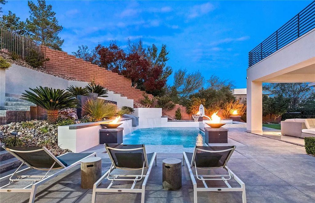 20 Skybird Court, Las Vegas, Nevada is a fully remodeled gem in the enclave of Redhawk behind the guard gates of The Ridges boasting a basketball area, pool with water slide and oversized wet deck, an indoor/outdoor bar, firepit, outdoor kitchen with ceiling mounted infrared heaters, and a wine cellar.