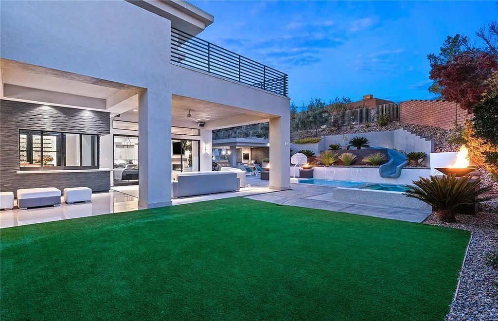 20 Skybird Court, Las Vegas, Nevada is a fully remodeled gem in the enclave of Redhawk behind the guard gates of The Ridges boasting a basketball area, pool with water slide and oversized wet deck, an indoor/outdoor bar, firepit, outdoor kitchen with ceiling mounted infrared heaters, and a wine cellar.