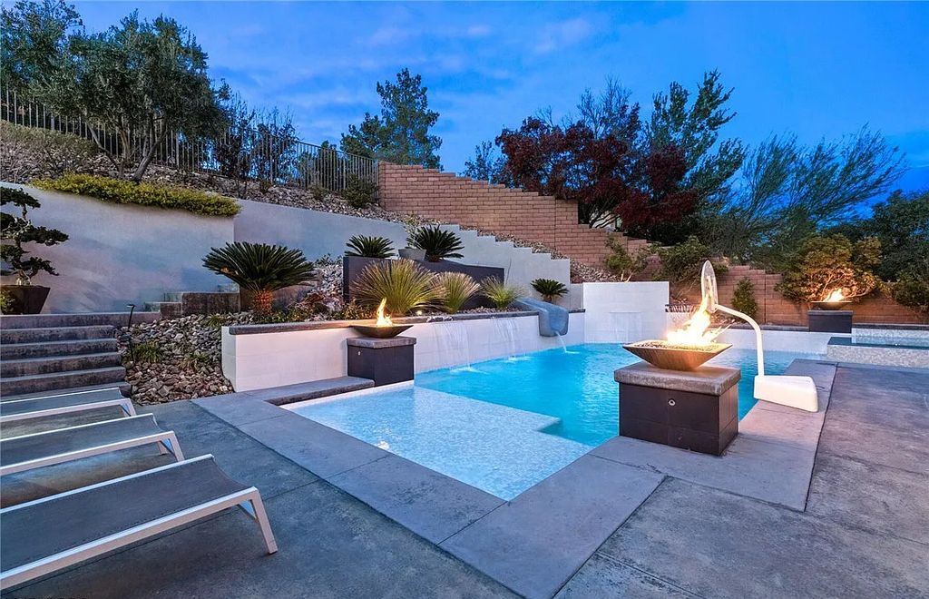 20 Skybird Court, Las Vegas, Nevada is a fully remodeled gem in the enclave of Redhawk behind the guard gates of The Ridges boasting a basketball area, pool with water slide and oversized wet deck, an indoor/outdoor bar, firepit, outdoor kitchen with ceiling mounted infrared heaters, and a wine cellar.