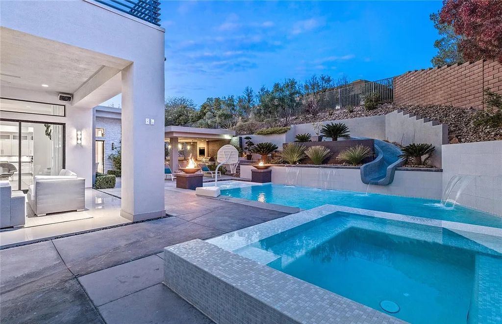 20 Skybird Court, Las Vegas, Nevada is a fully remodeled gem in the enclave of Redhawk behind the guard gates of The Ridges boasting a basketball area, pool with water slide and oversized wet deck, an indoor/outdoor bar, firepit, outdoor kitchen with ceiling mounted infrared heaters, and a wine cellar.